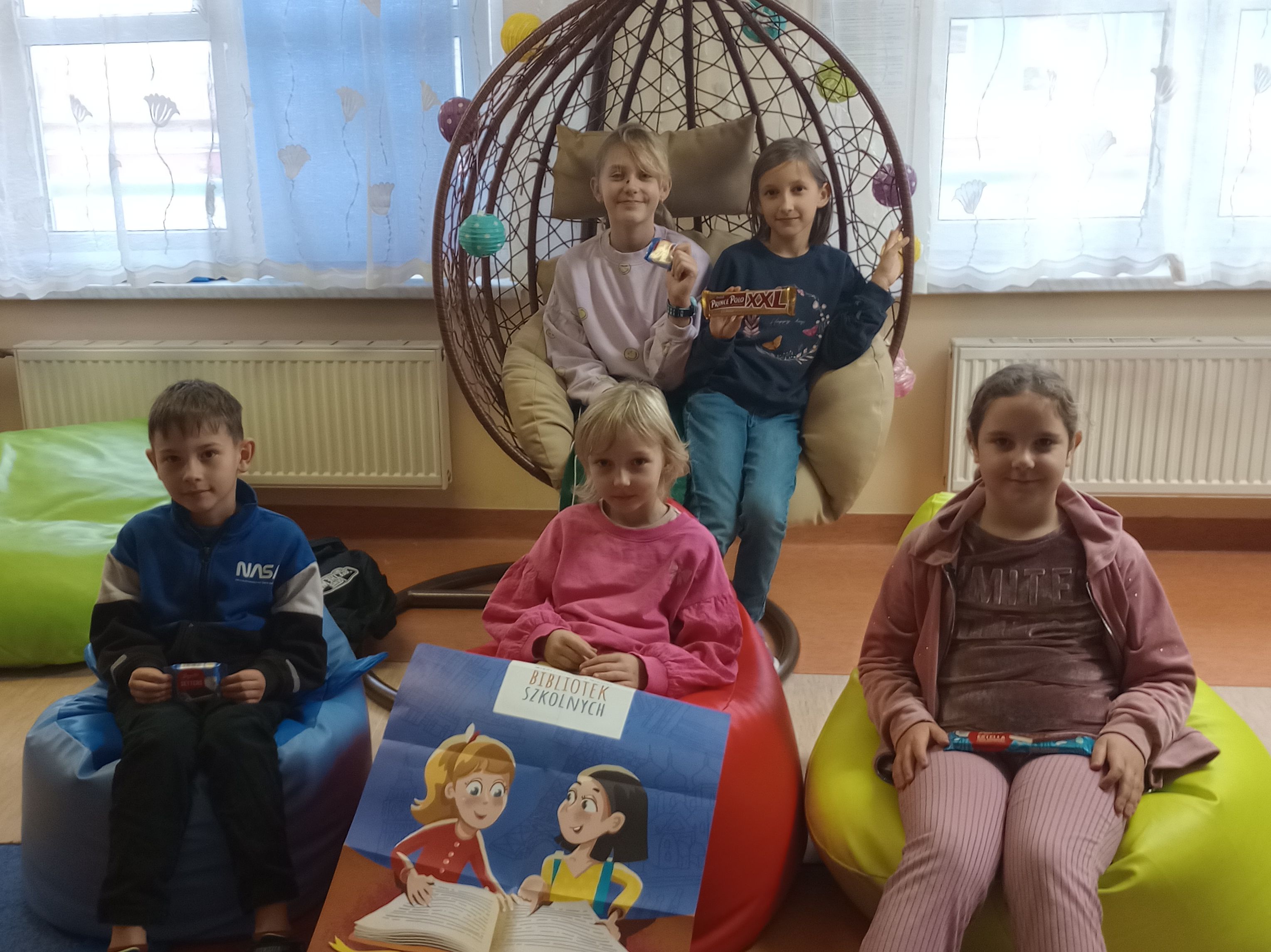 Uśmiechnięci uczniowie siedzą na pufach sako oraz kokonie.